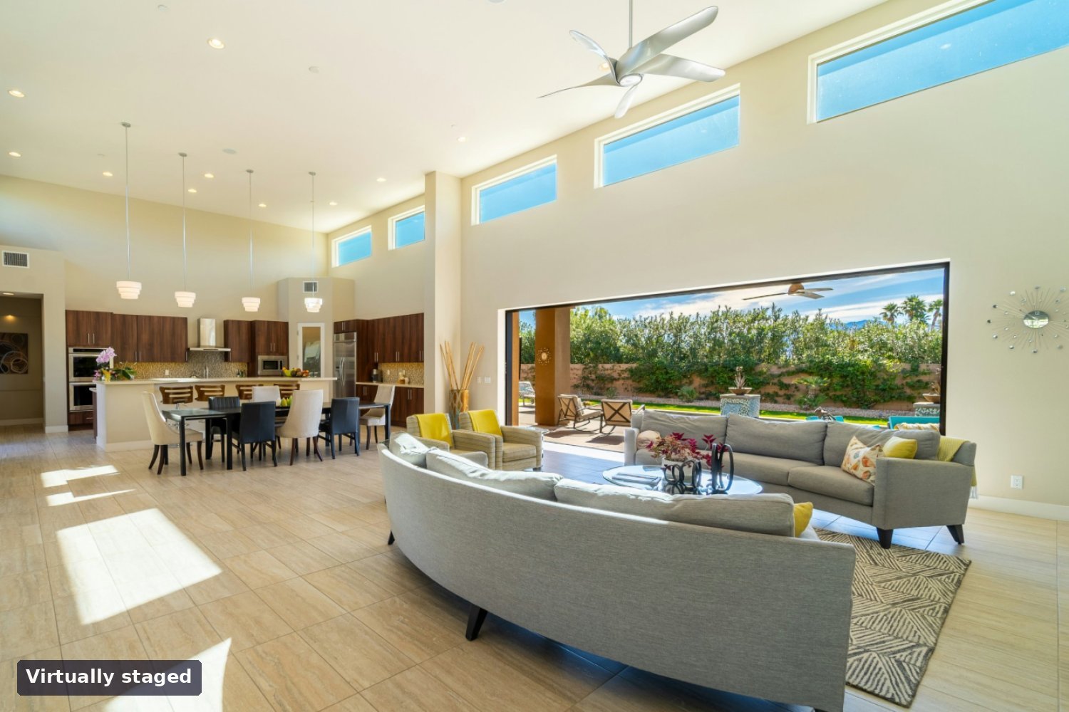 Same great room virtually staged with sofas, lounge chairs and a rug
